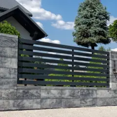 Nowoczesny płot betonowy z elementami metalowymi, idealny do ogrodu. Zastanawiasz się, ile kosztuje płot betonowy? Ten przykład pokazuje jego estetykę.