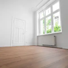 Puste, jasne pomieszczenie z drzwiami i oknem. Zastanawiasz się, ile się czeka na mieszkanie komunalne?