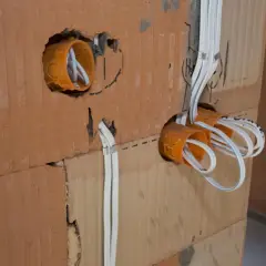 Instalacja elektryczna w trakcie budowy. Widoczne puszki instalacyjne i przewody. Sprawdź nasz cennik usług elektrycznych.