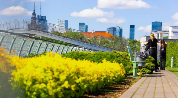 Dwie dziewczyny patrzą na panoramę Warszawy, zastanawiając się nad cenami wynajmu mieszkań w stolicy.