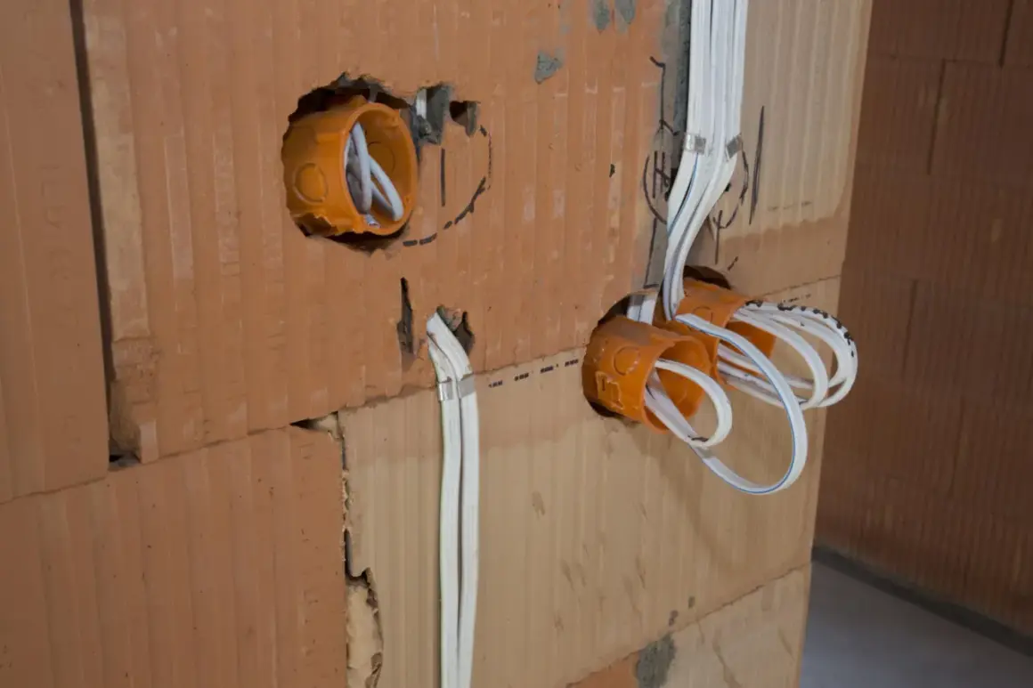 Instalacja elektryczna w trakcie budowy. Widoczne puszki instalacyjne i przewody. Sprawdź nasz cennik usług elektrycznych.