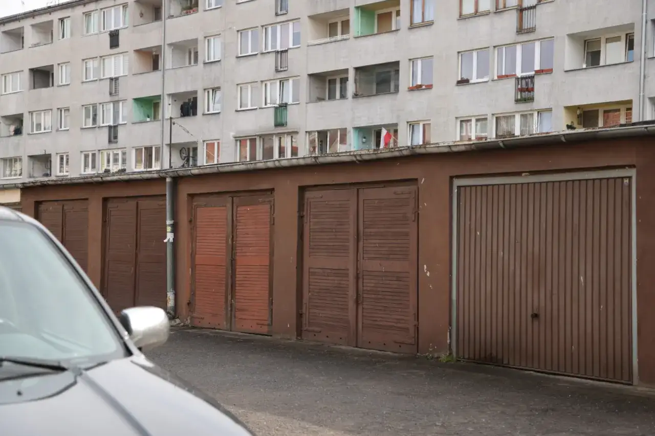 Blok mieszkalny z balkonami i garażami. Ile miejsc parkingowych na mieszkanie? Trudno ocenić, ale garaży jest sporo.