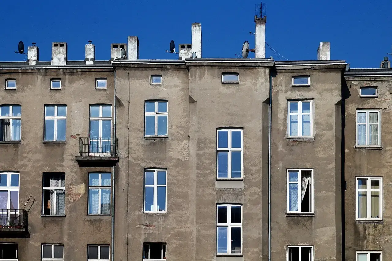 Elewacja kamienicy w Warszawie, z wieloma oknami i balkonami. Marzenie o wykupie mieszkania komunalnego w Warszawie może się tu spełnić.