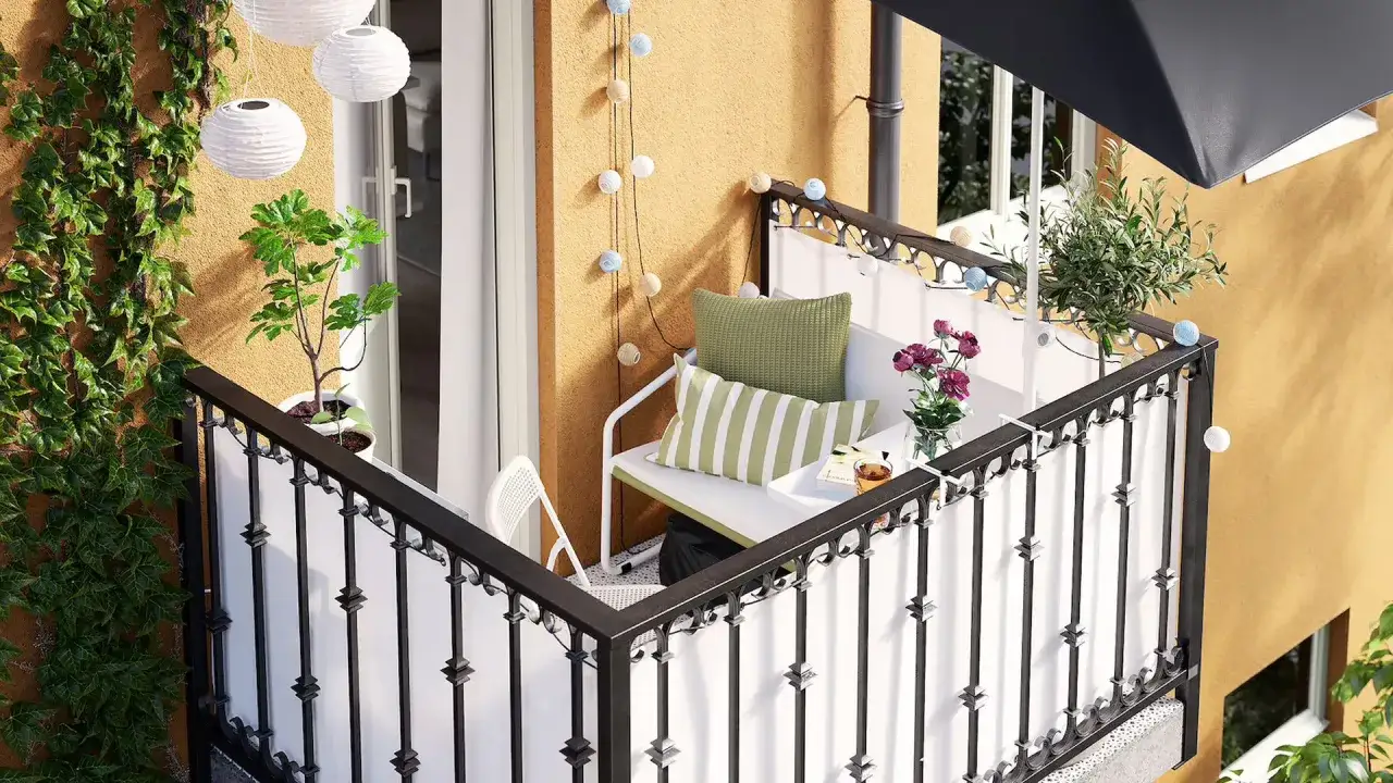 Przytulny balkon wnękowy z roślinami, meblami i girlandą świetlną. Idealne miejsce na relaks.