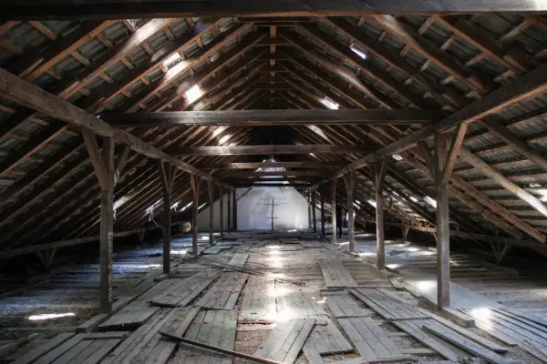 Drewniane poddasze 80m2, gotowe do adaptacji. Widok na konstrukcję dachu i deski podłogowe.