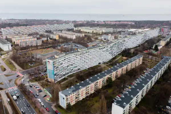 Długi, falisty blok mieszkalny i inne budynki w osiedlu. Kiedy najem prywatny staje się działalnością gospodarczą, takie widoki mogą przypominać o skali inwestycji.
