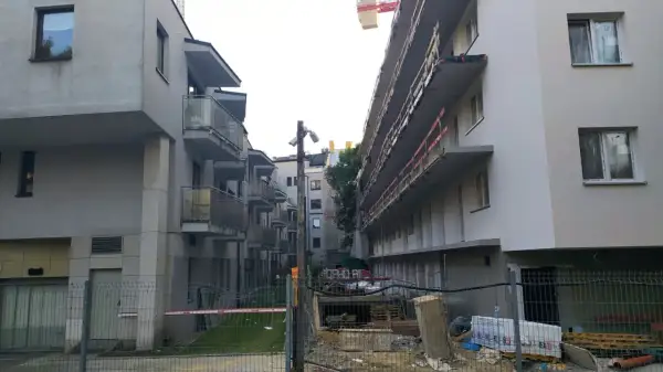 Budowa osiedla, gdzie widać betonowe balkony i rusztowania. To przykład patodeweloperki, gdzie liczy się szybki zysk, a nie jakość.