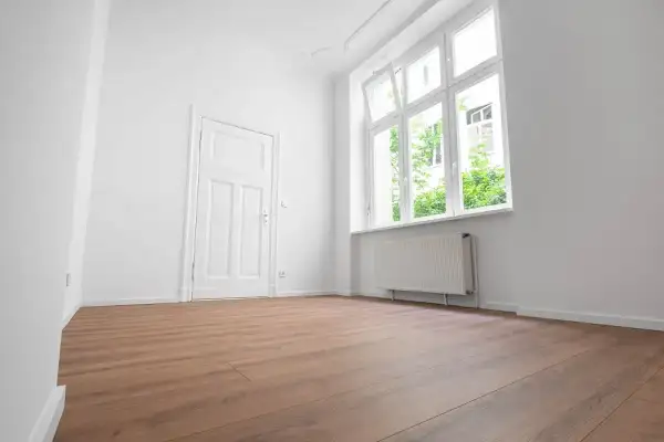 Puste, jasne pomieszczenie z drzwiami i oknem. Zastanawiasz się, ile się czeka na mieszkanie komunalne?